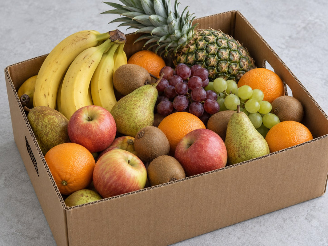 Große, dicht gefüllte Obstkiste mit Ananas, Bananen, Äpfeln und weiteren Früchten.