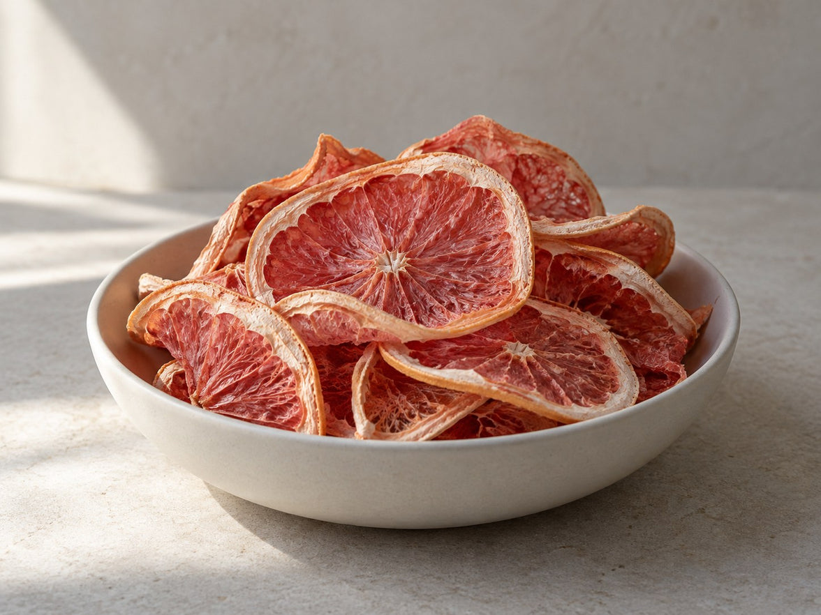 Getrocknete Grapefruitscheiben in einer hellen Keramikschale.