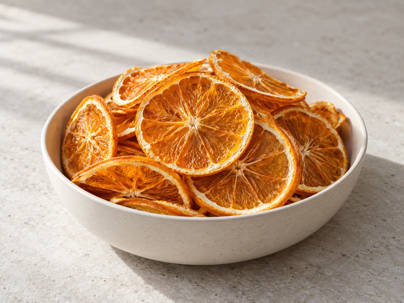 Getrocknete Orangenscheiben in einer hellen Keramikschale.
