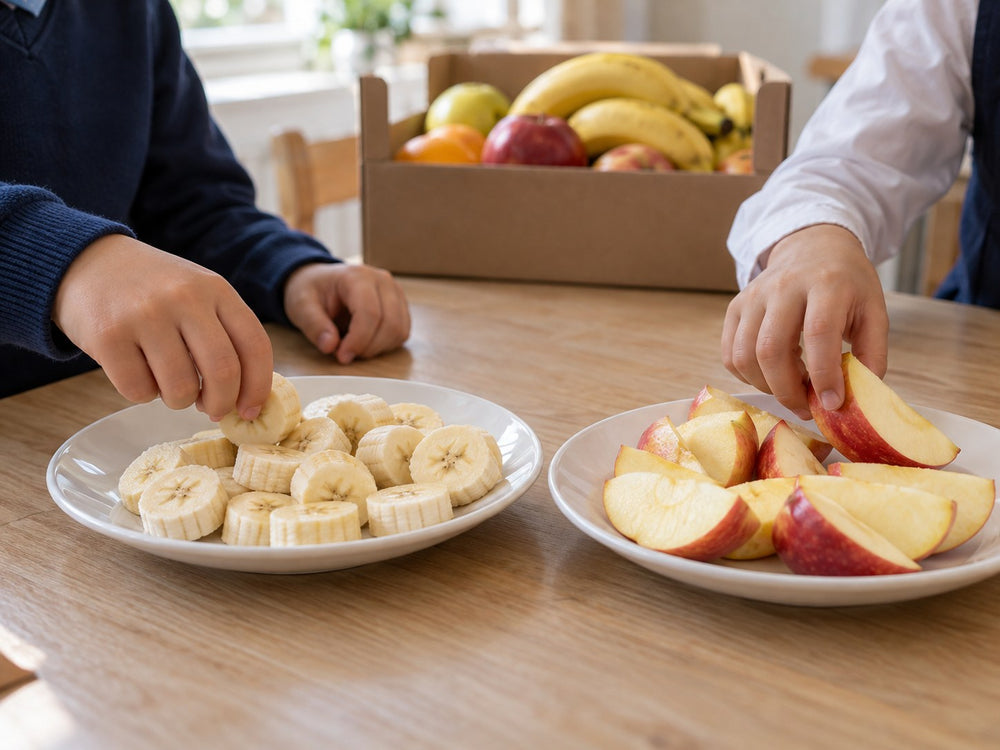 Kinderhände greifen in der Schulpause nach Apfel- und Bananenstücken.
