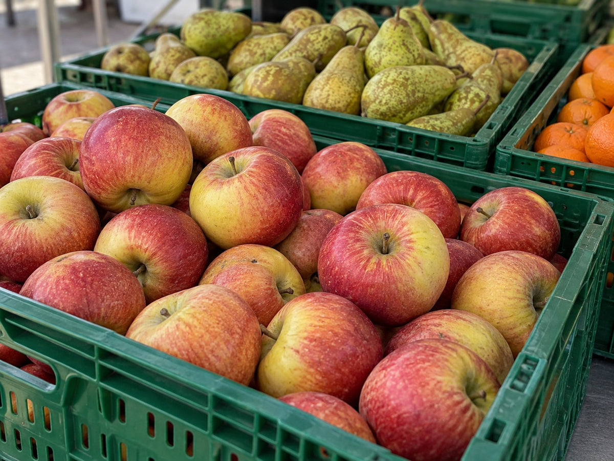 Äpfel und weitere Früchte in grünen Europool-Kisten am Wochenmarkt.